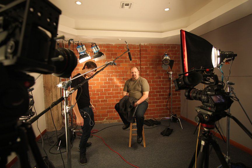 a man sitting in front of production equipment getting ready to film