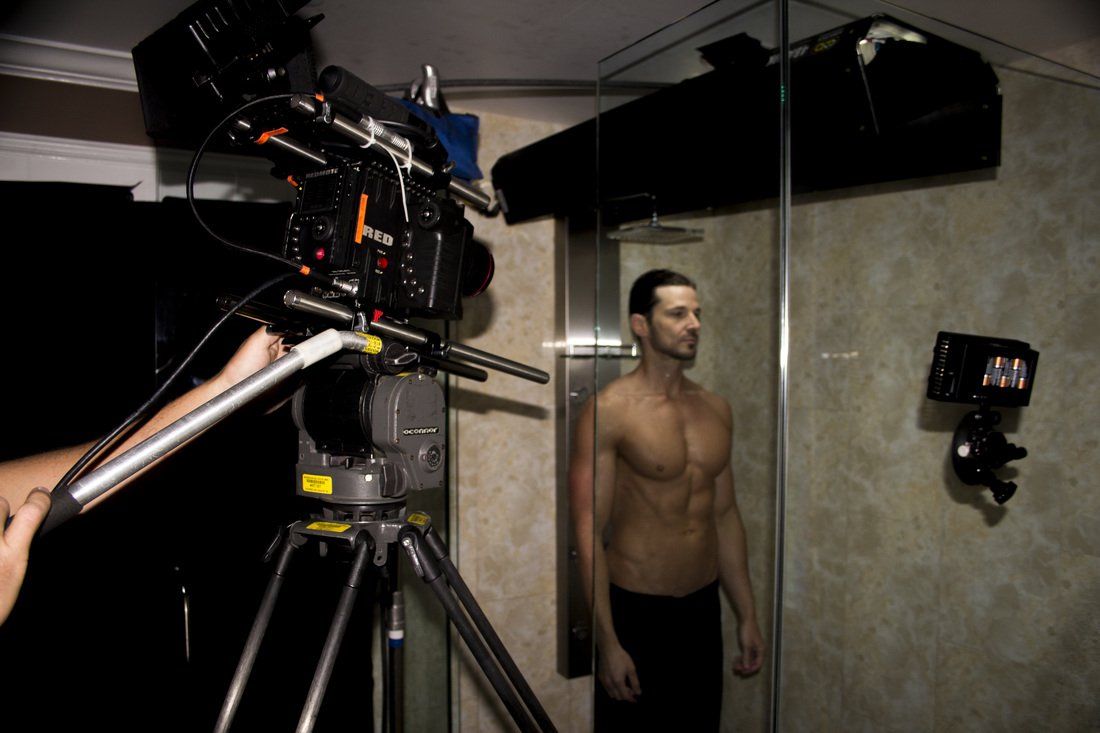 a young good looking man in the showering being filmed for a commercial