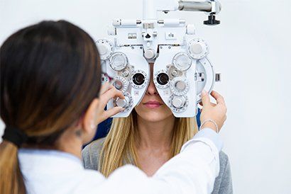Optician Standing While Doing Eye Test — Knoxville, TN — Allee Vision Optometry