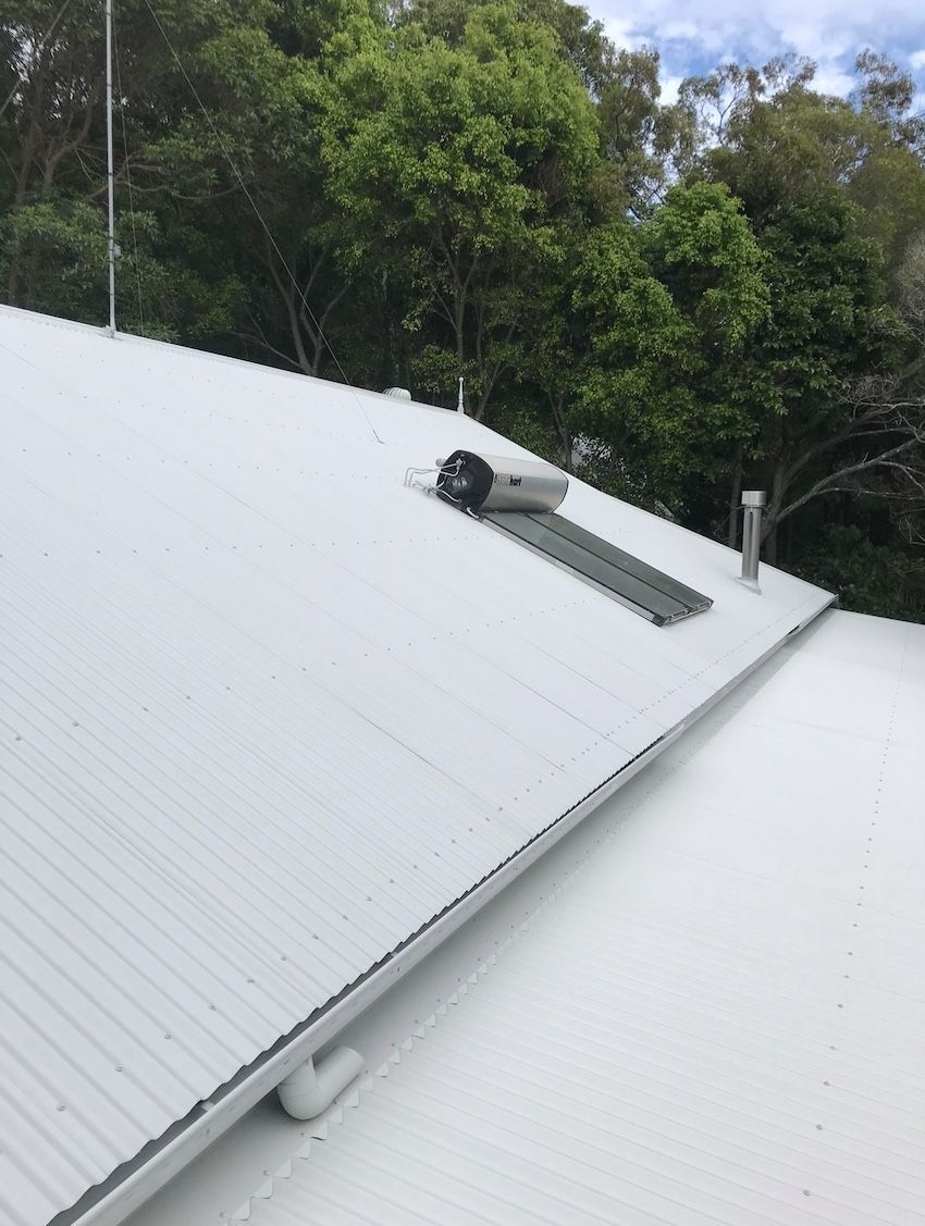 A White Roof With a Skylight on It and Trees in the Background — House & Roof Painting & Restorations In Maroochydore, QLD