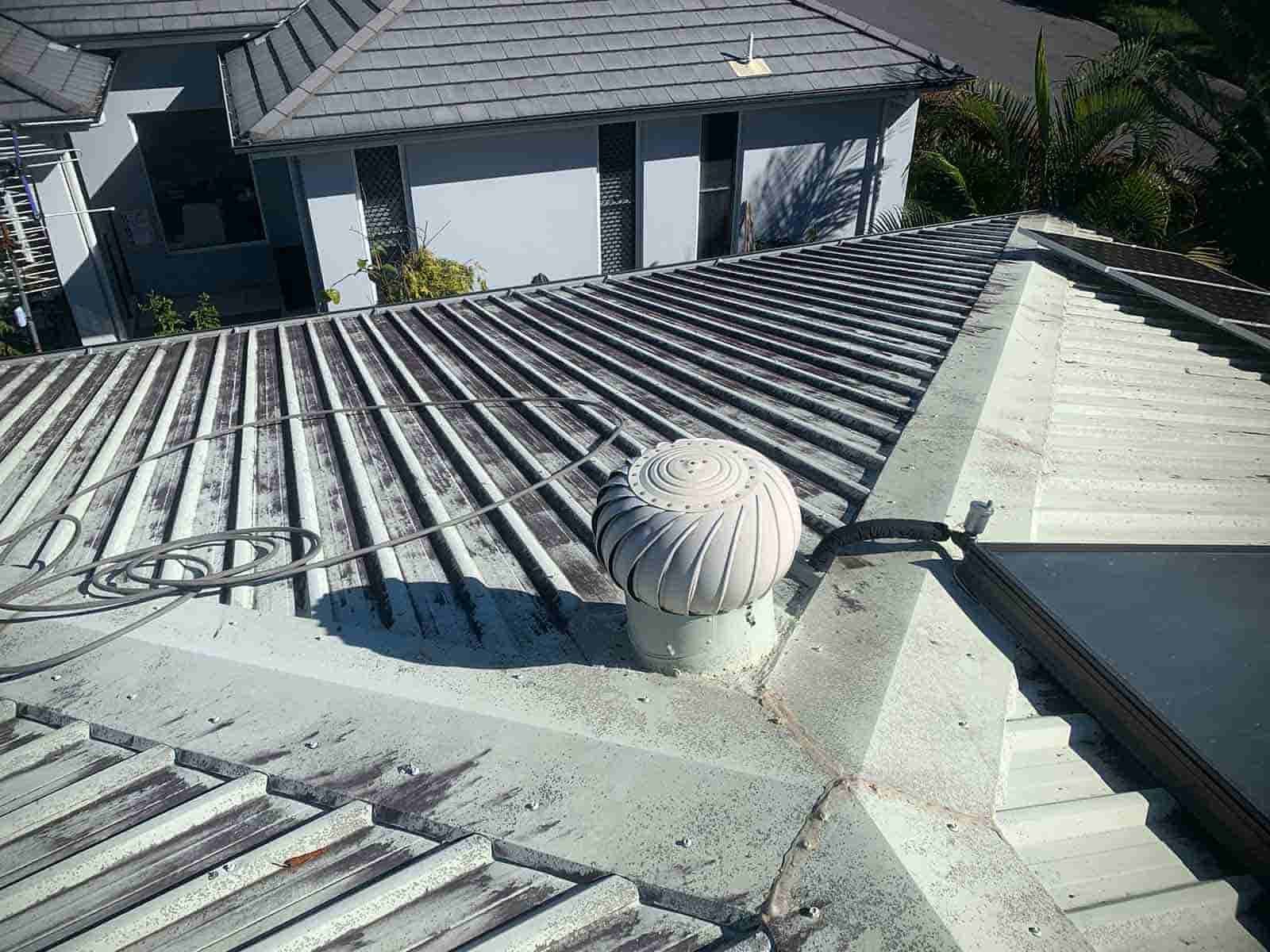 A Roof Of A House With A Circular Object On Top Of It — House & Roof Painting & Restorations In Maroochydore, QLD