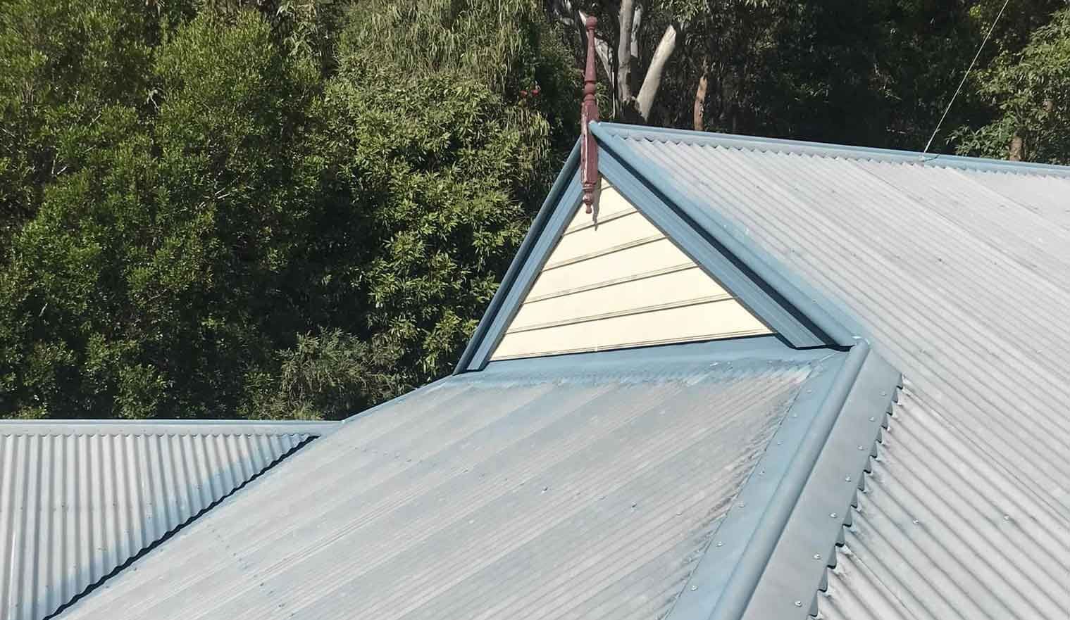 A Blue Roof With A Triangle On Top Of It — House & Roof Painting & Restorations In Maroochydore, QLD