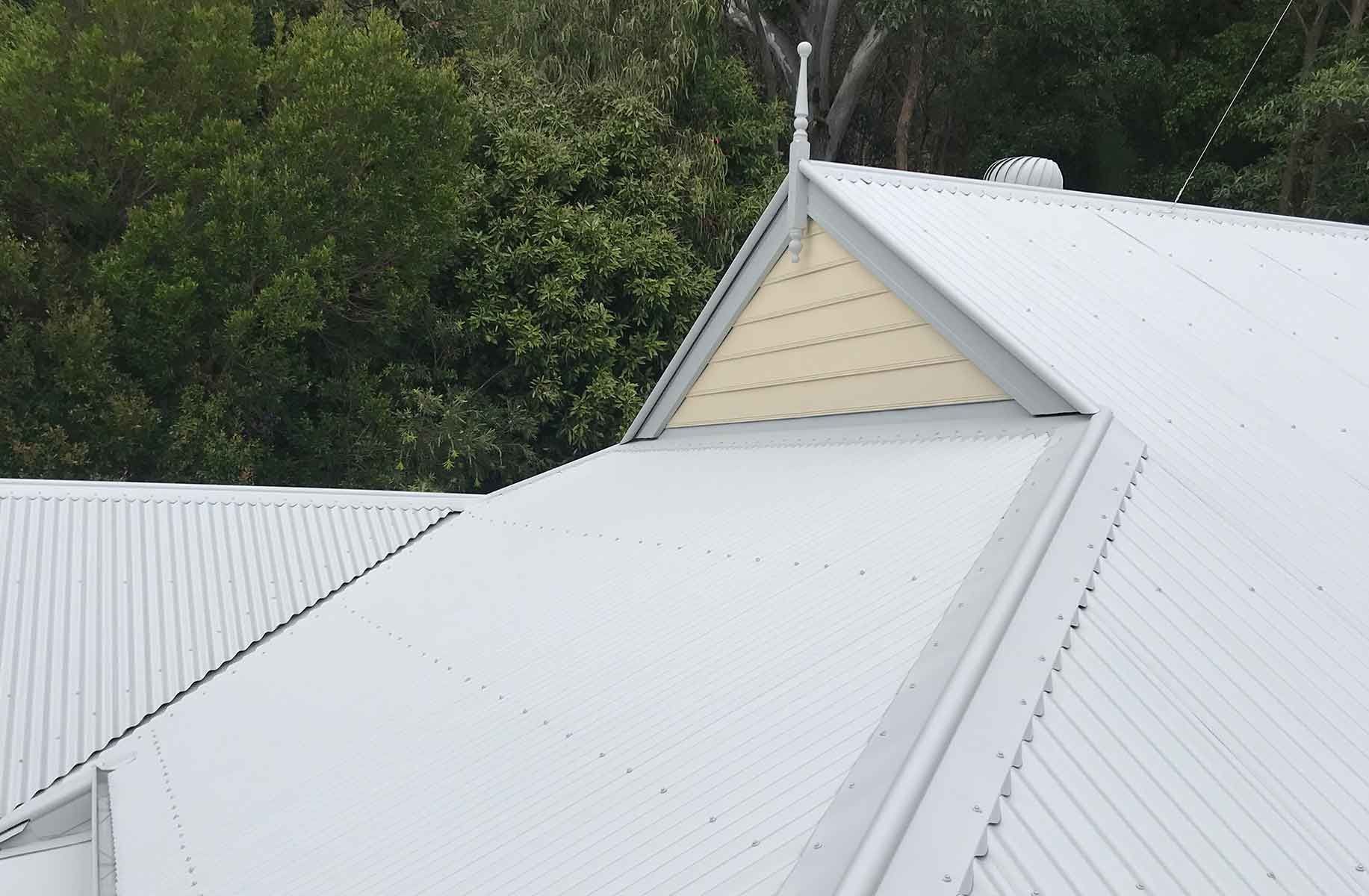 A White Roof With A Yellow Trim And Trees In The Background — House & Roof Painting & Restorations In Maroochydore, QLD