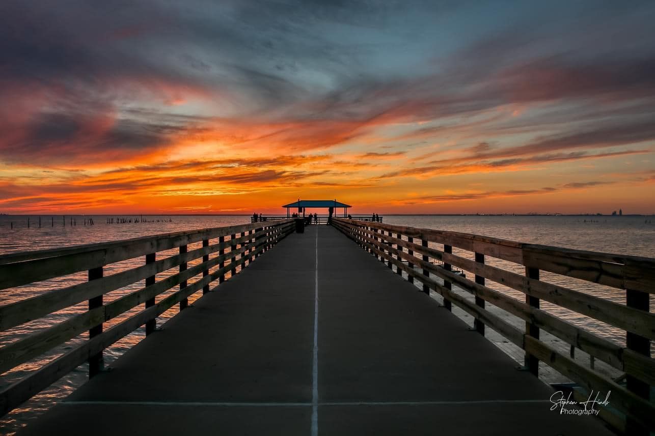 A photograph of a pier at sunset taken by stephen hude photography