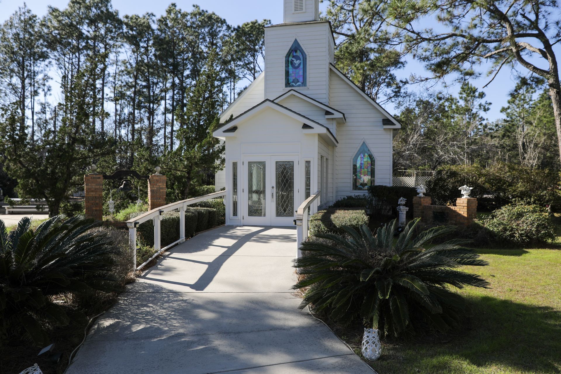A small white church with a stained glass window