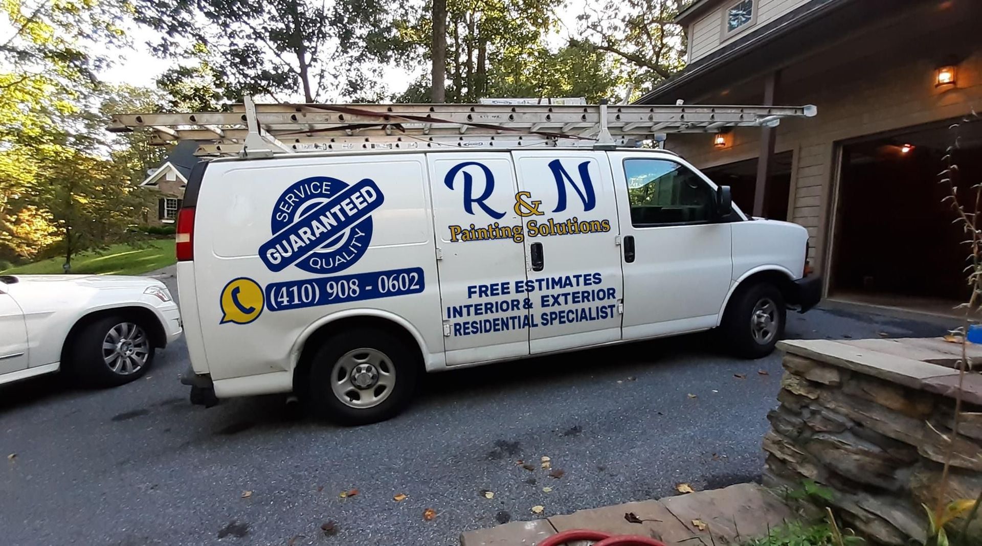 Furgoneta blanca con escalera, rotulada 