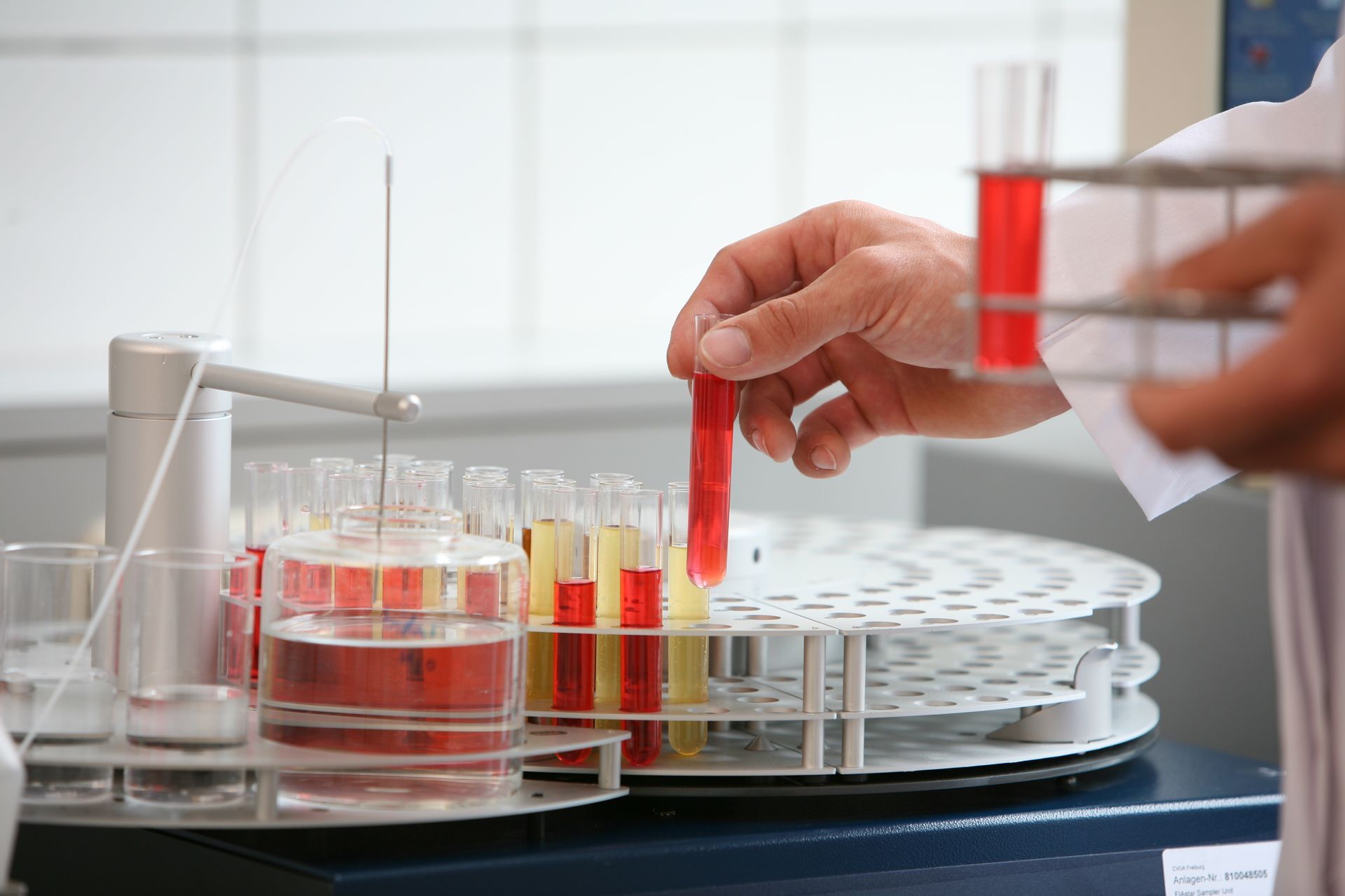 Eine Chemielaborantin pippetiert eine Flüssigkeit