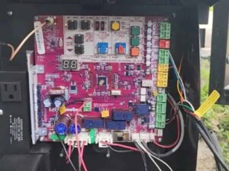 A close up of a motherboard with a lot of wires coming out of it.