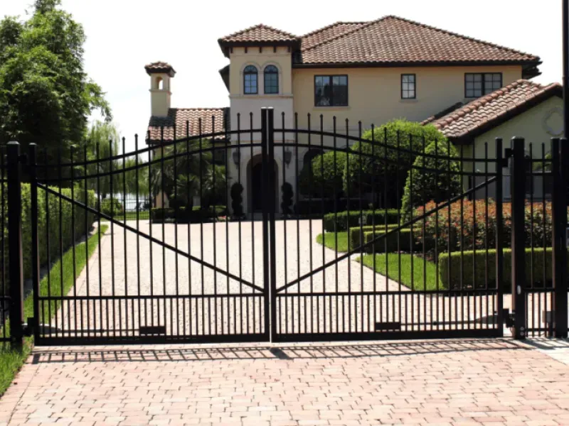 A large house with a black gate leading to it