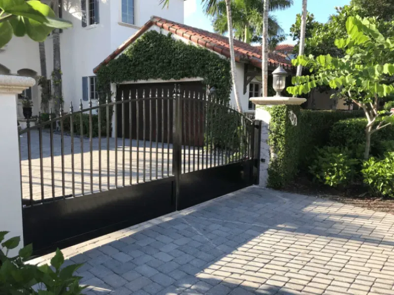 A white house with a black gate in front of it