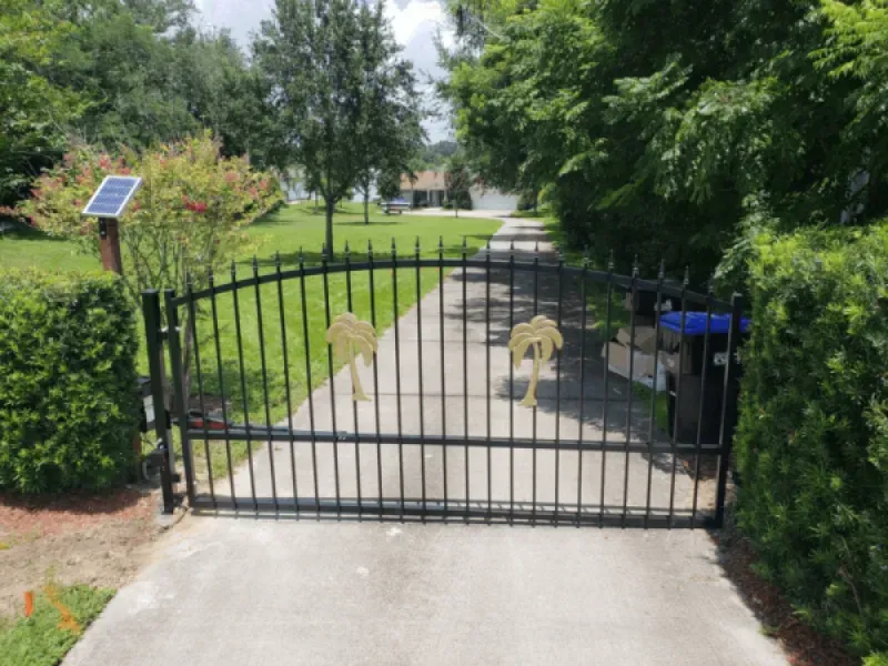 A wrought iron gate with a solar panel on top of it