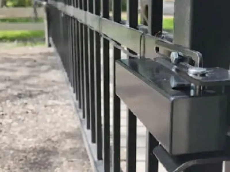 A close up of a sliding gate with a motor attached to it.