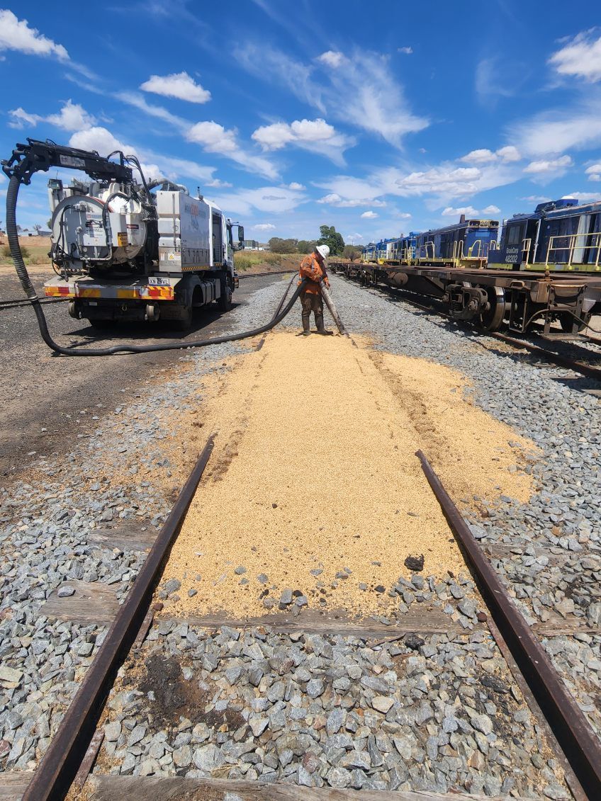 A team member cleaning a spill from a railway line.