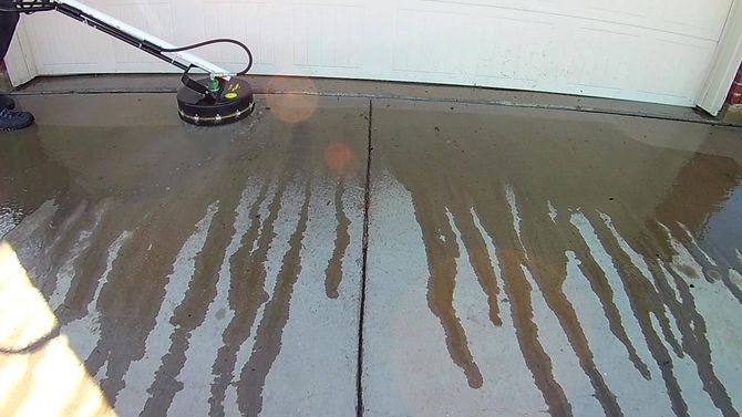 A person is cleaning a concrete floor with a machine A person is cleaning a concrete floor with a machine