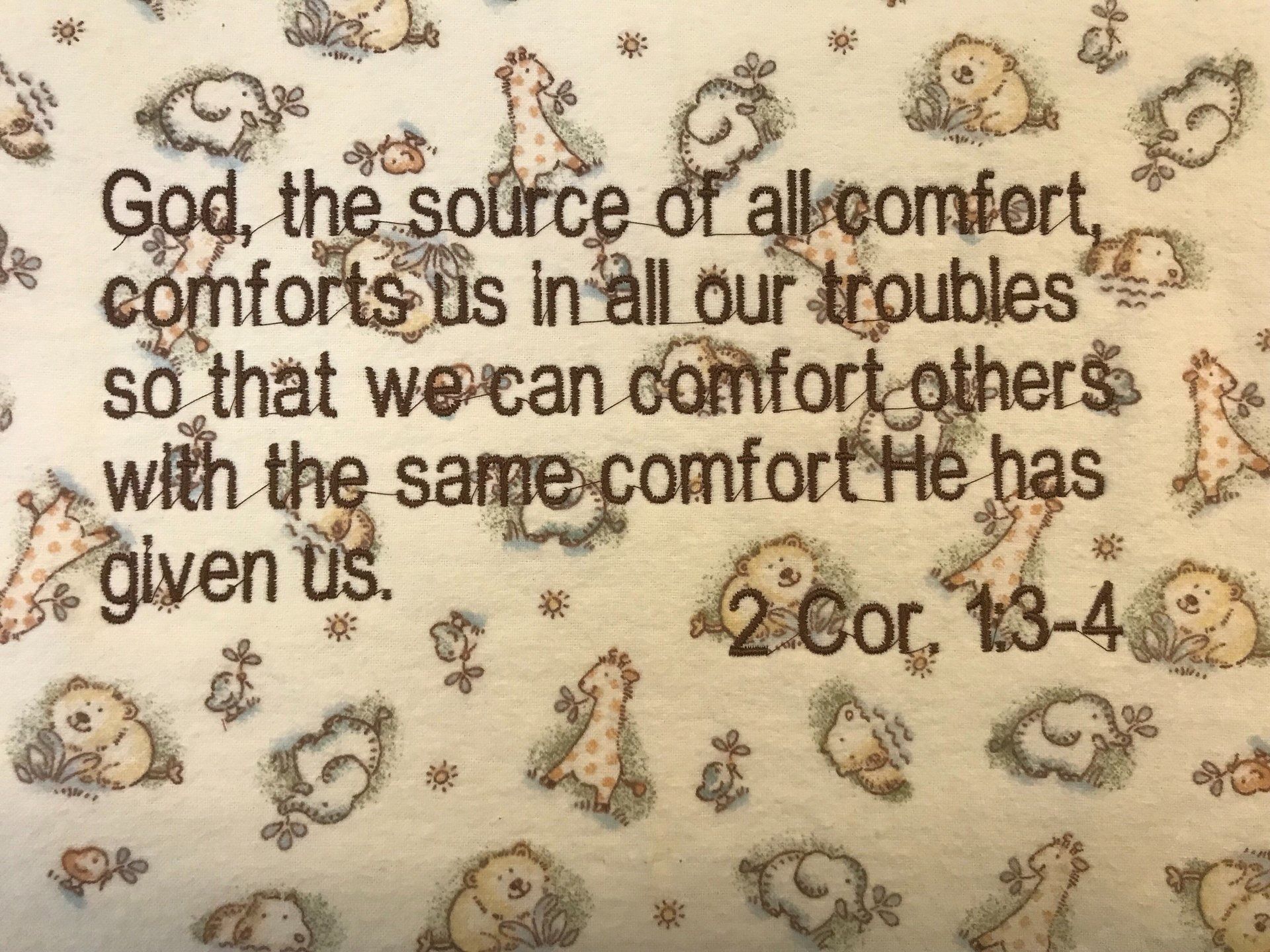 A baby-themed print with illustrations of kittens, lambs, and ducks, featuring the text 2 Cor. 1:3-4 about divine comfort.