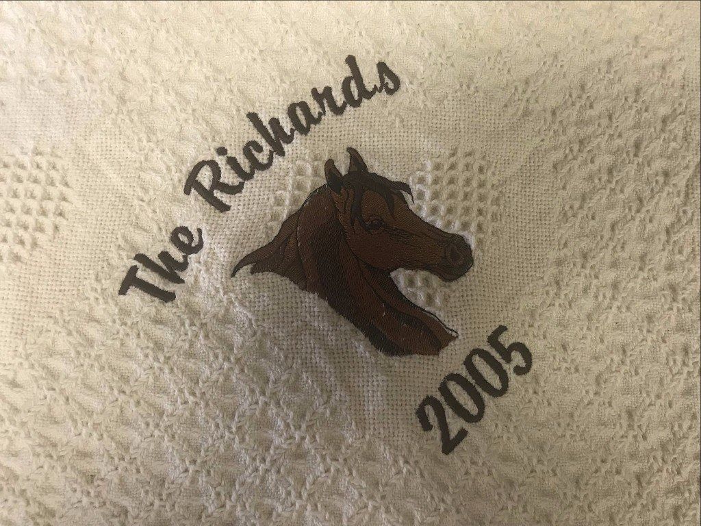 An embroidered brown horse head, the text 
