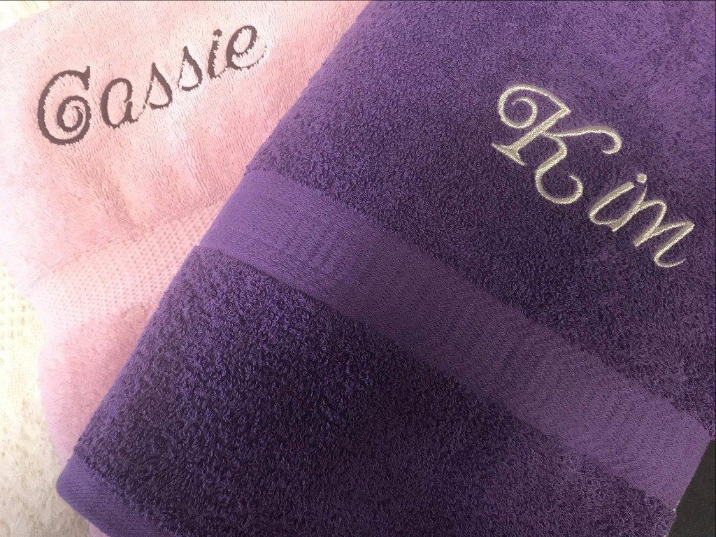 A pink towel embroidered with the name 