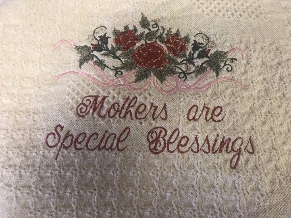 A cross-stitch embroidery on fabric reading 