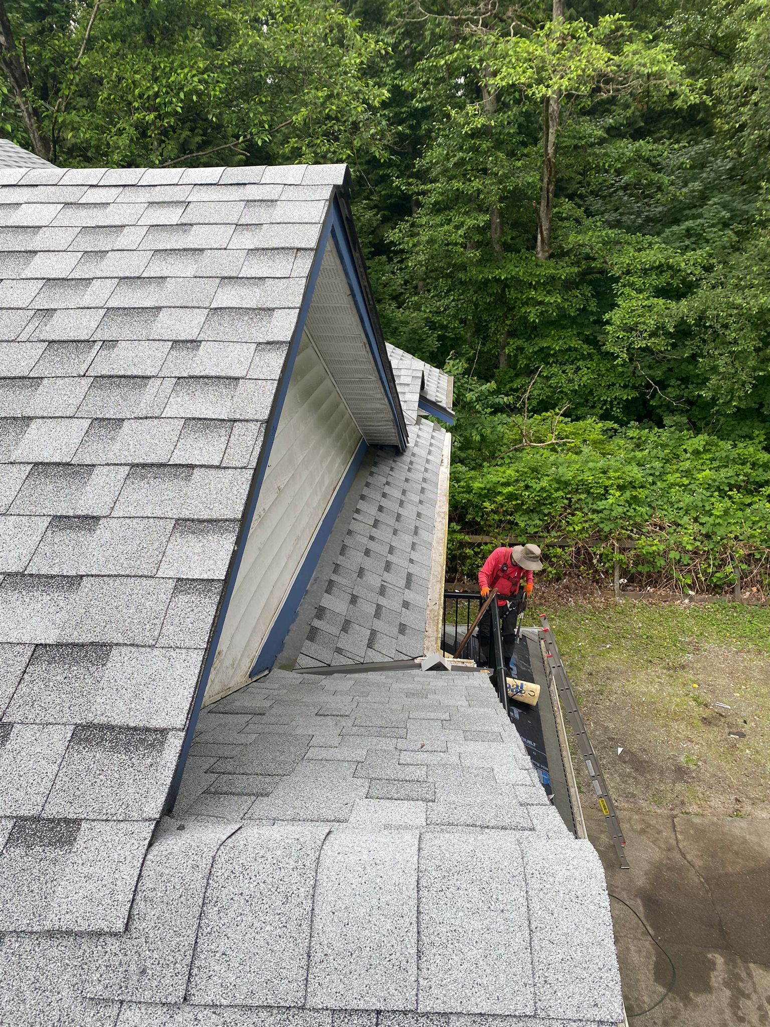 A man is working on the roof of a house.
