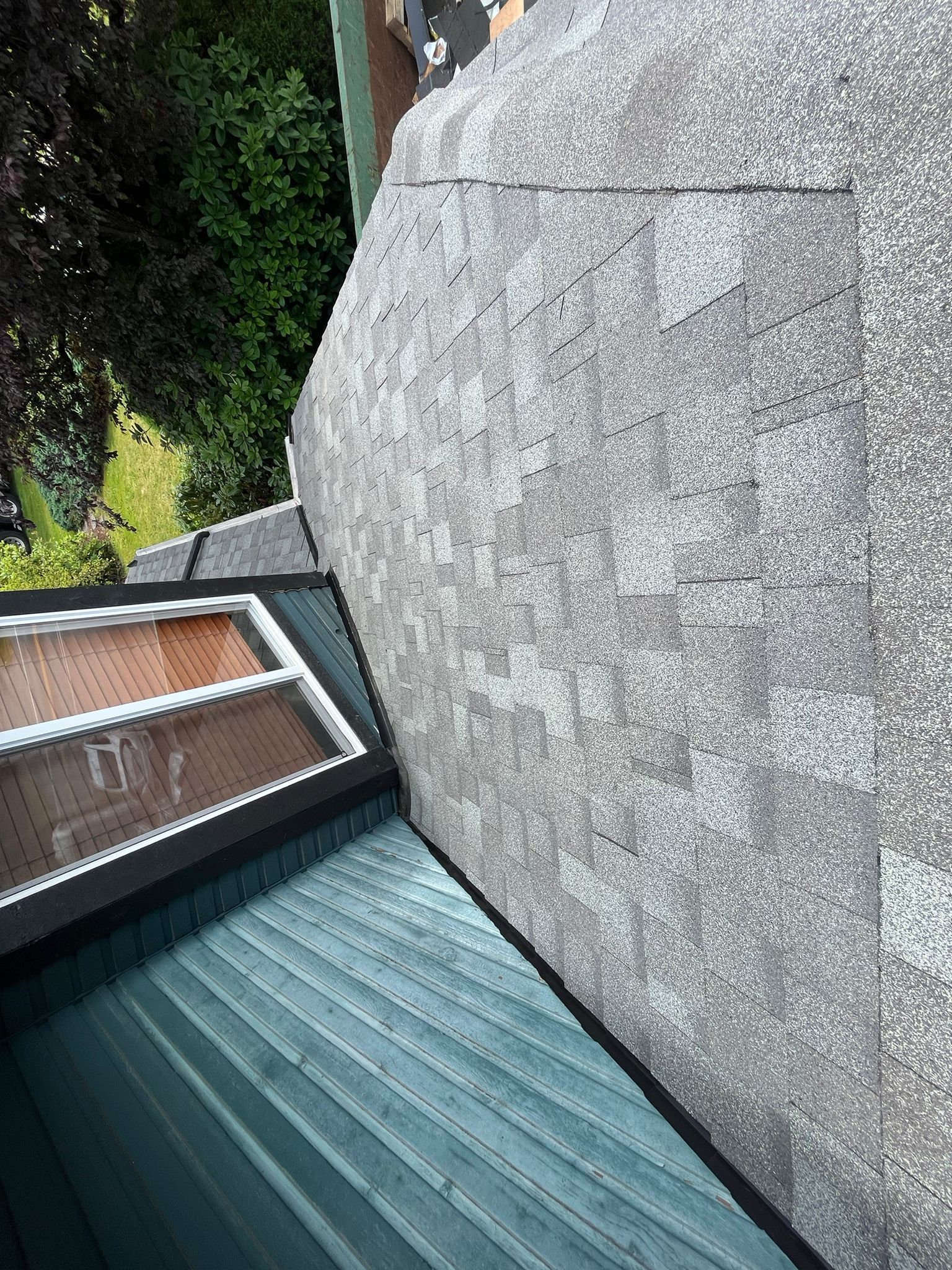 A roof with a skylight and a window on it.