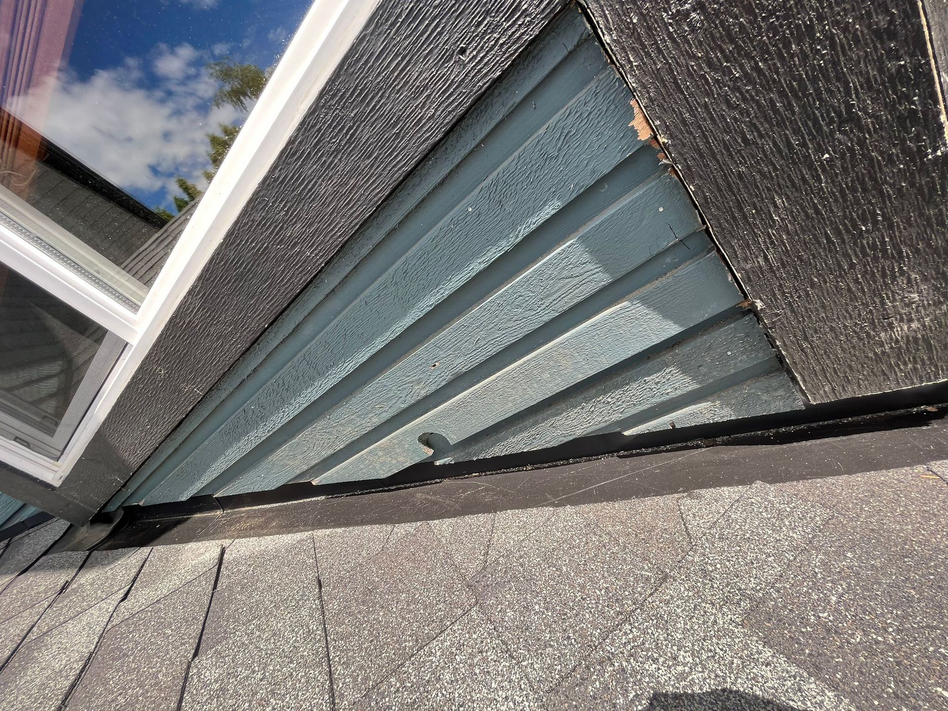 A close up of a window with a reflection of the sky in it.