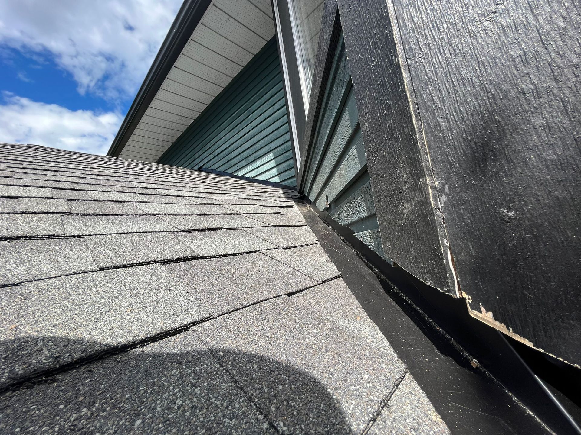 A close up of a roof with a house in the background.