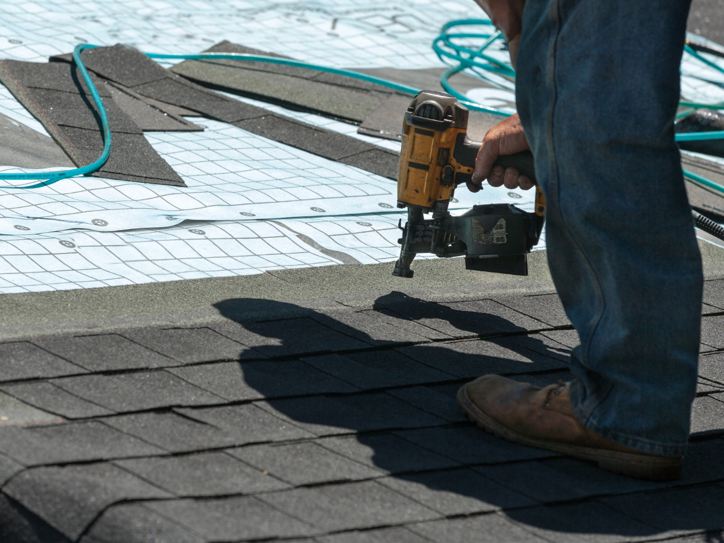 A roof with a vent on it and a building in the background.
