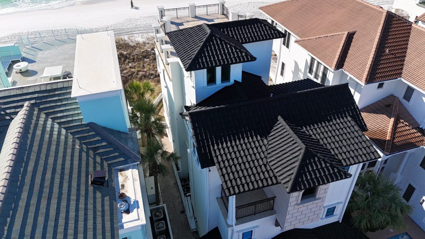 A roof with a vent on it and a building in the background.