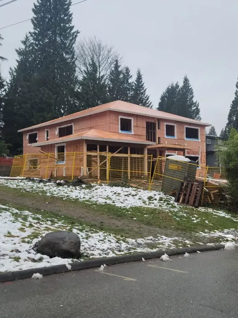 A house under construction with snow on the ground