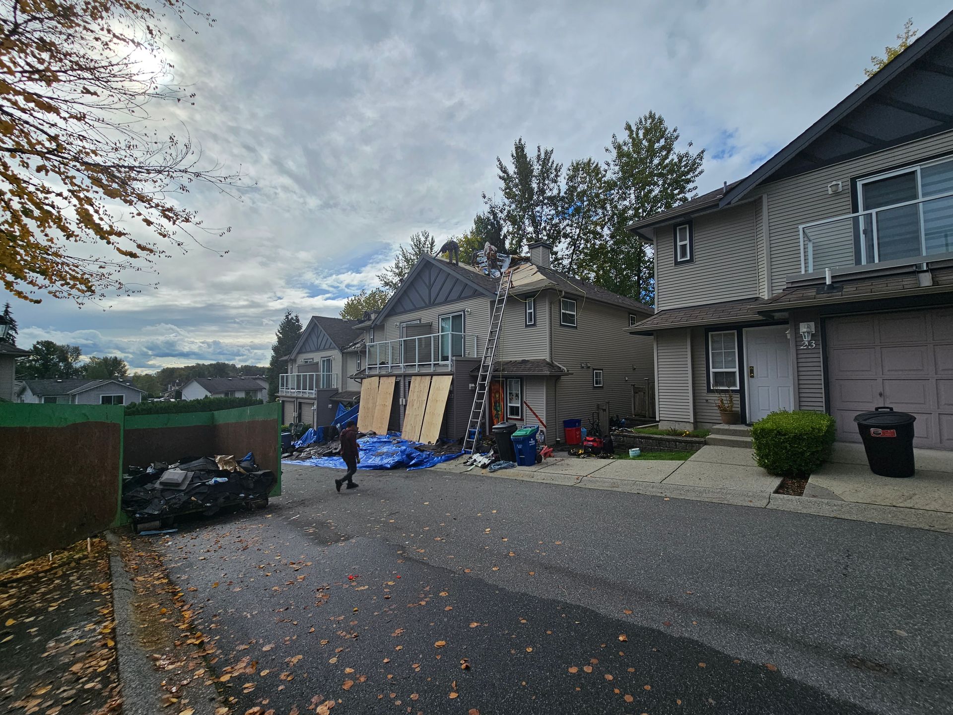 A man is walking down a street in front of a row of houses.