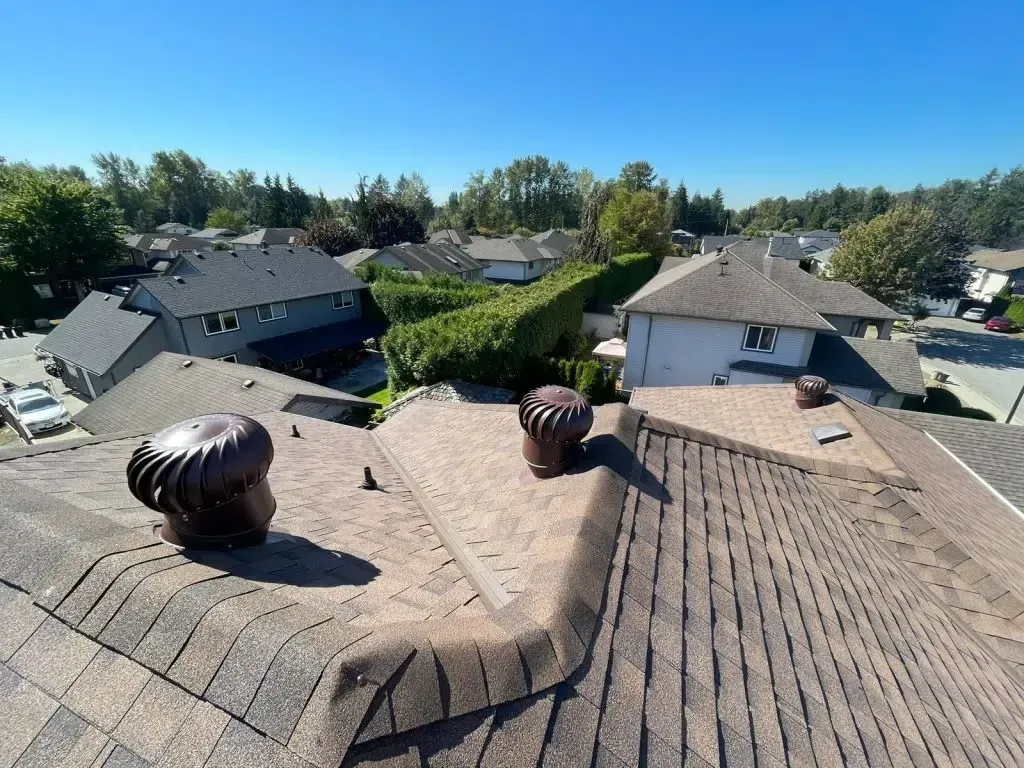 An aerial view of a roof with two wind turbine vents on it.