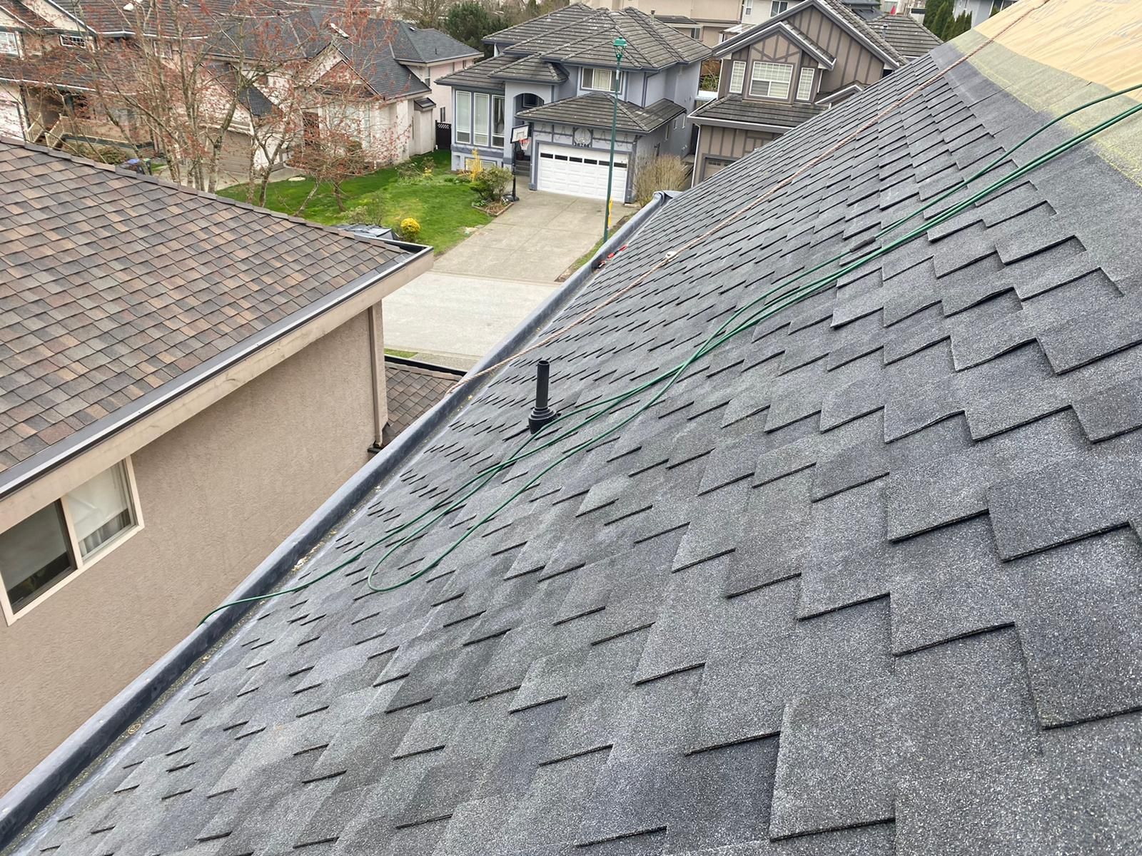 An aerial view of a roof of a house in a residential area.