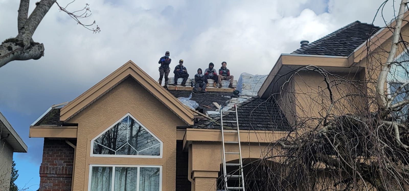 A group of people are standing on the roof of a house.