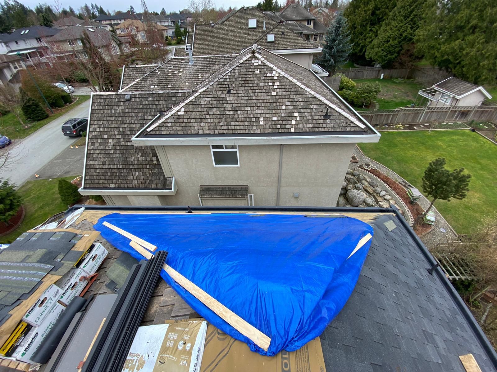 A blue tarp is covering the roof of a house