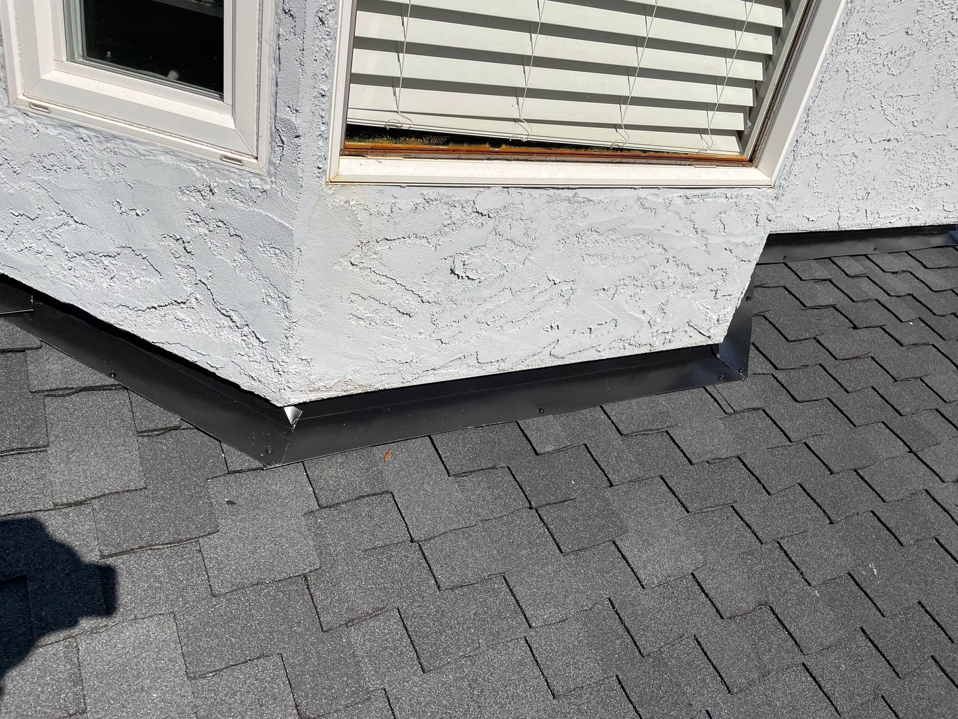 A roof with a window and blinds on it.