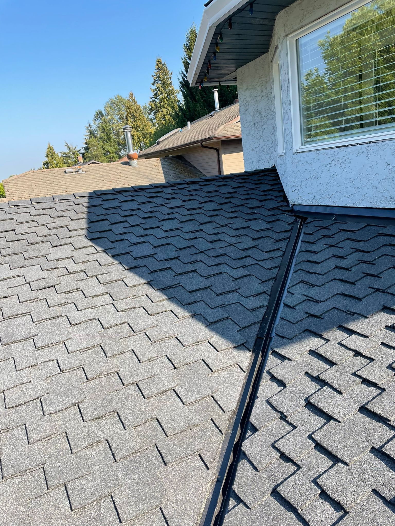 A close up of a roof of a house with a window.