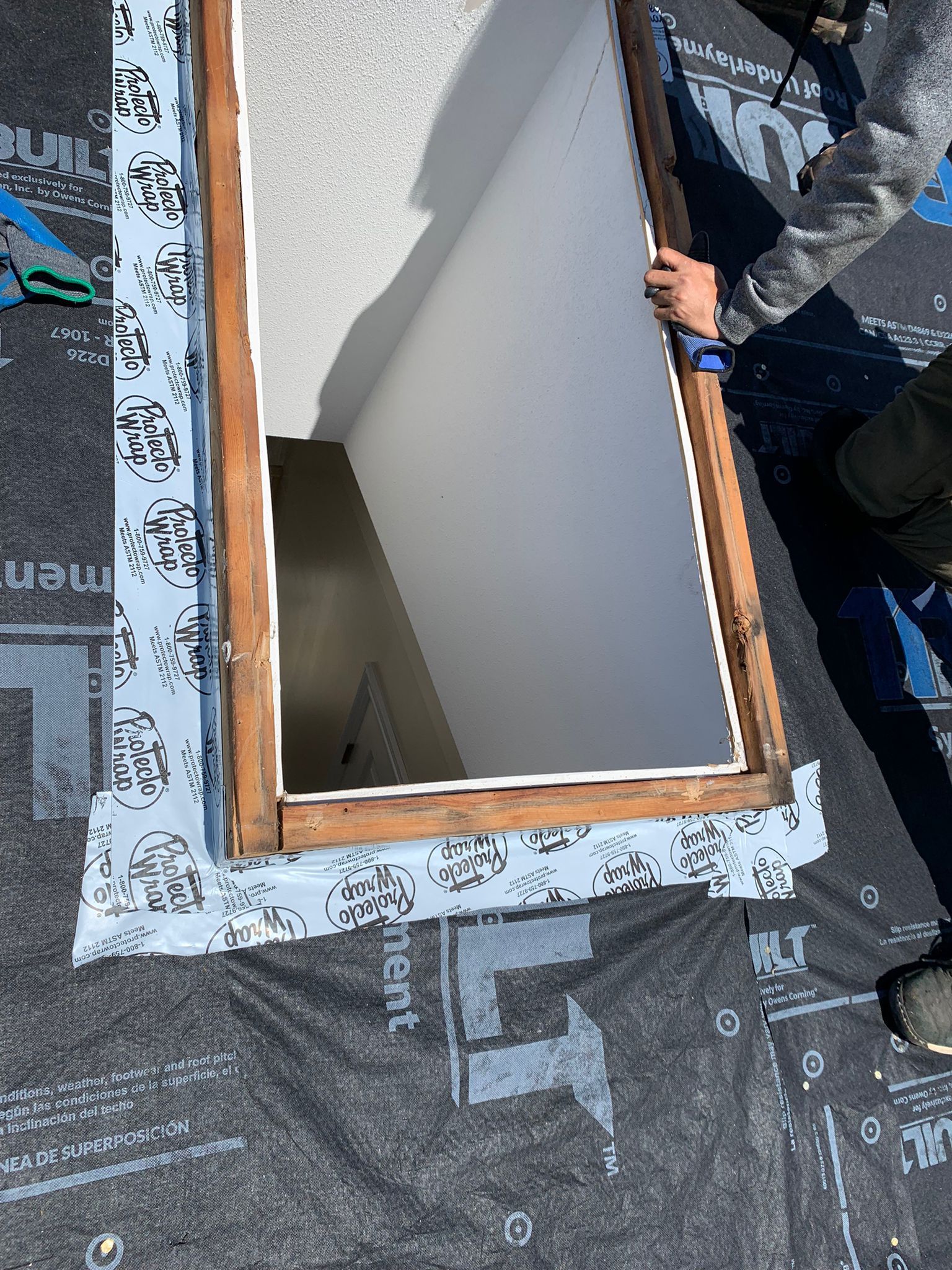 roofer working on a skylight window repair on a roof.