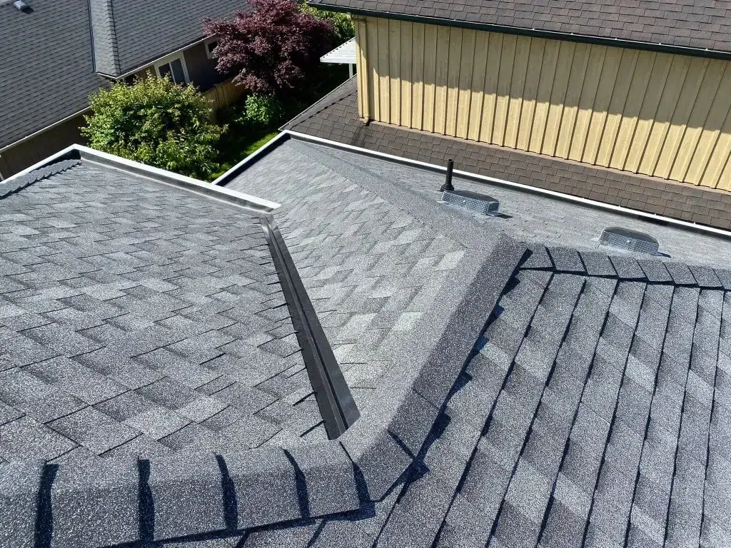 An aerial view of a roof of a house with a yellow building in the background.