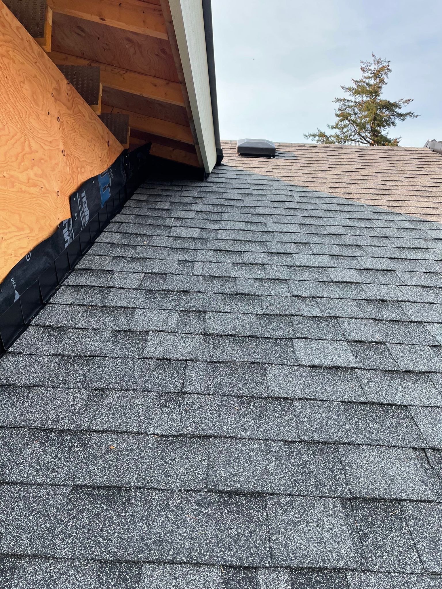 A close up of a roof with shingles being installed.