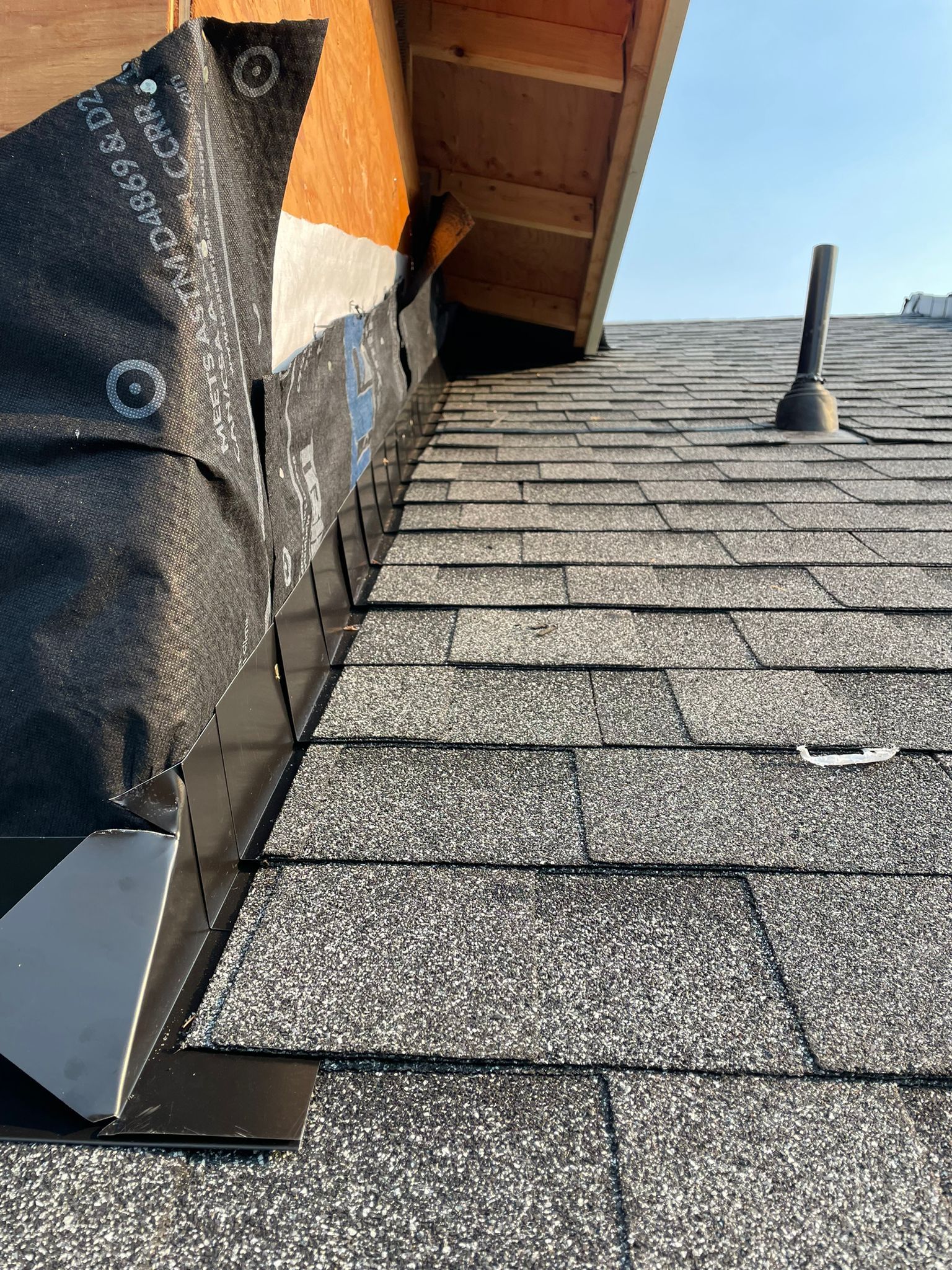 A close up of a roof with shingles being installed.