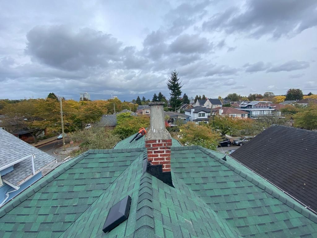 A green roof with a chimney on top of it.