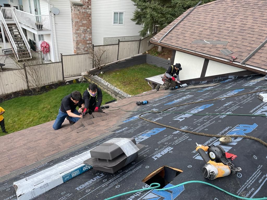 A group of people are working on the roof of a house.