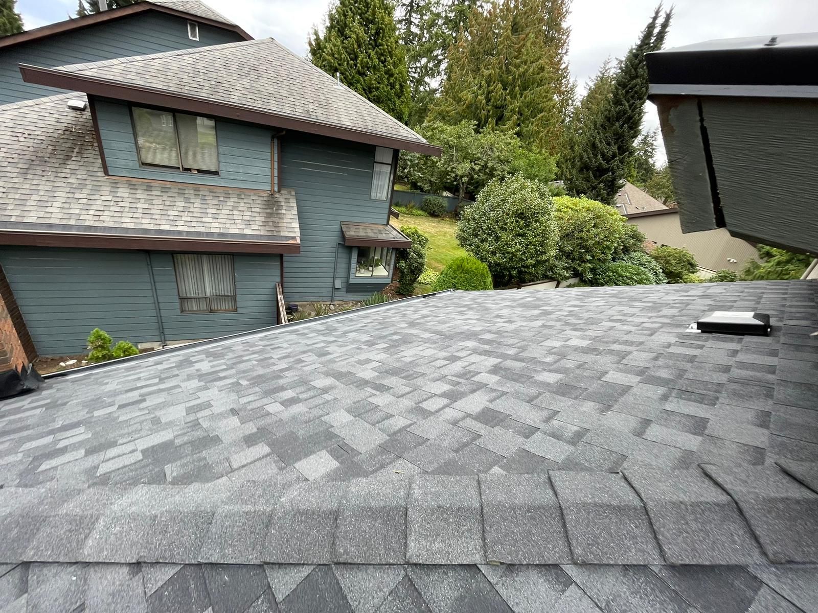 The roof of a house with a gray shingle roof.