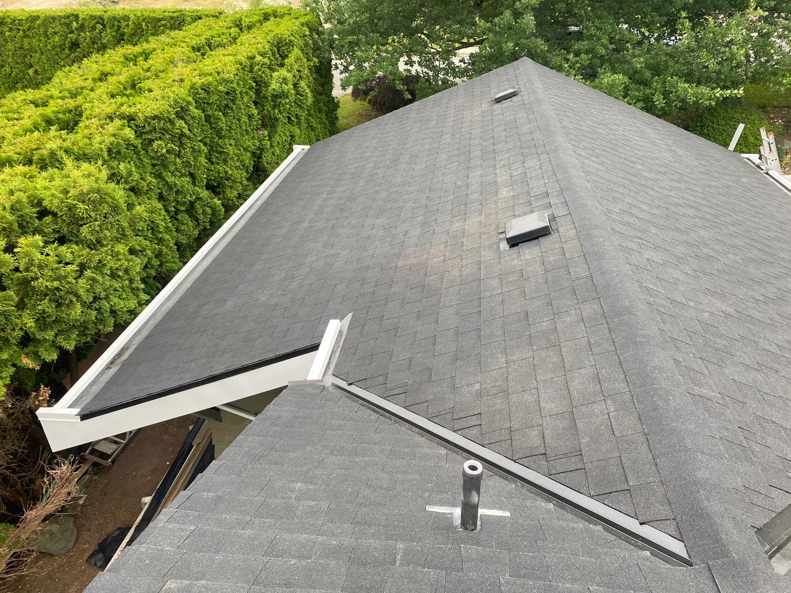 The roof of a house with a gutter and a skylight.