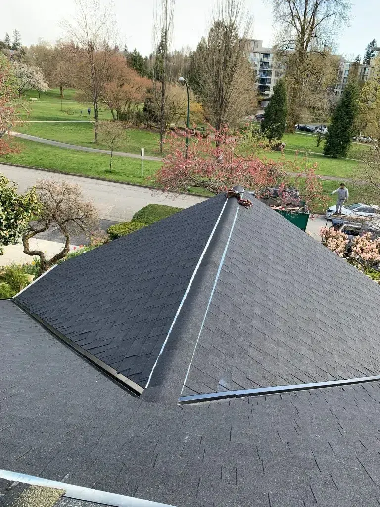 An aerial view of a roof with new fiberglass shingles installed