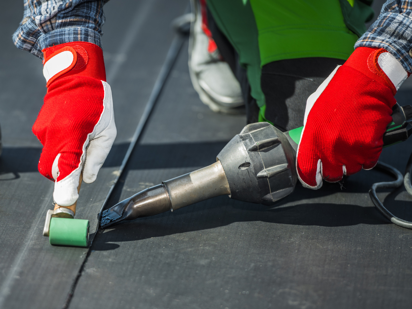 A roof with a vent on it and a building in the background.