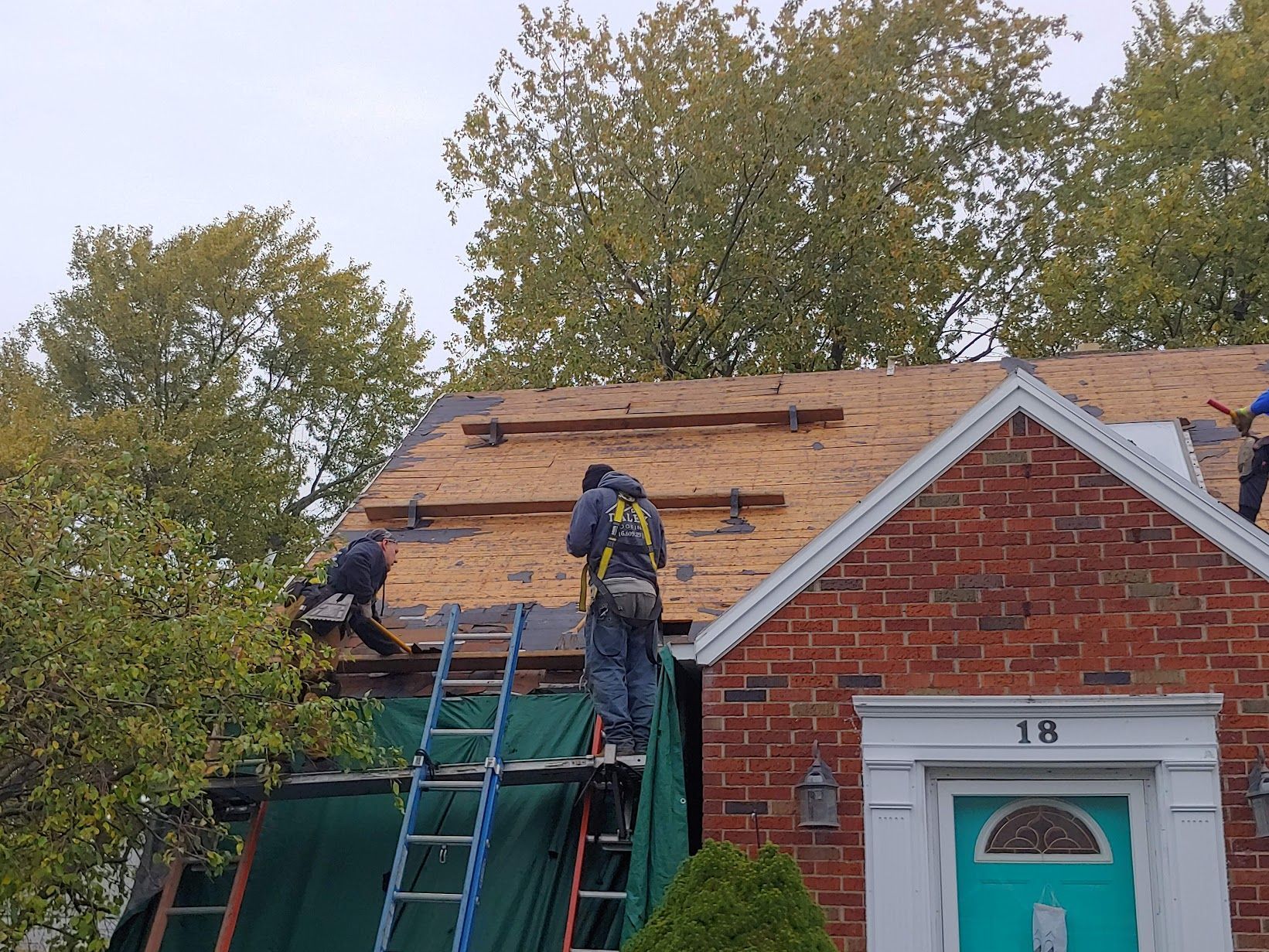 A roof with a vent on it and a building in the background.