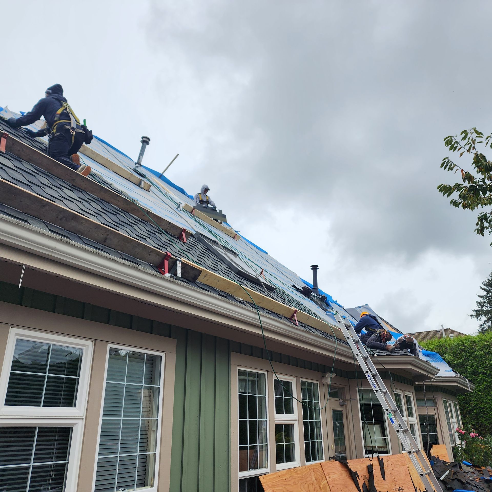 A group of roofers are working on the roof of a house.