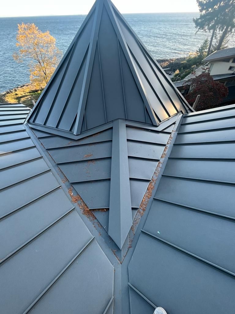 A roof with a cone on top of it overlooking the ocean.