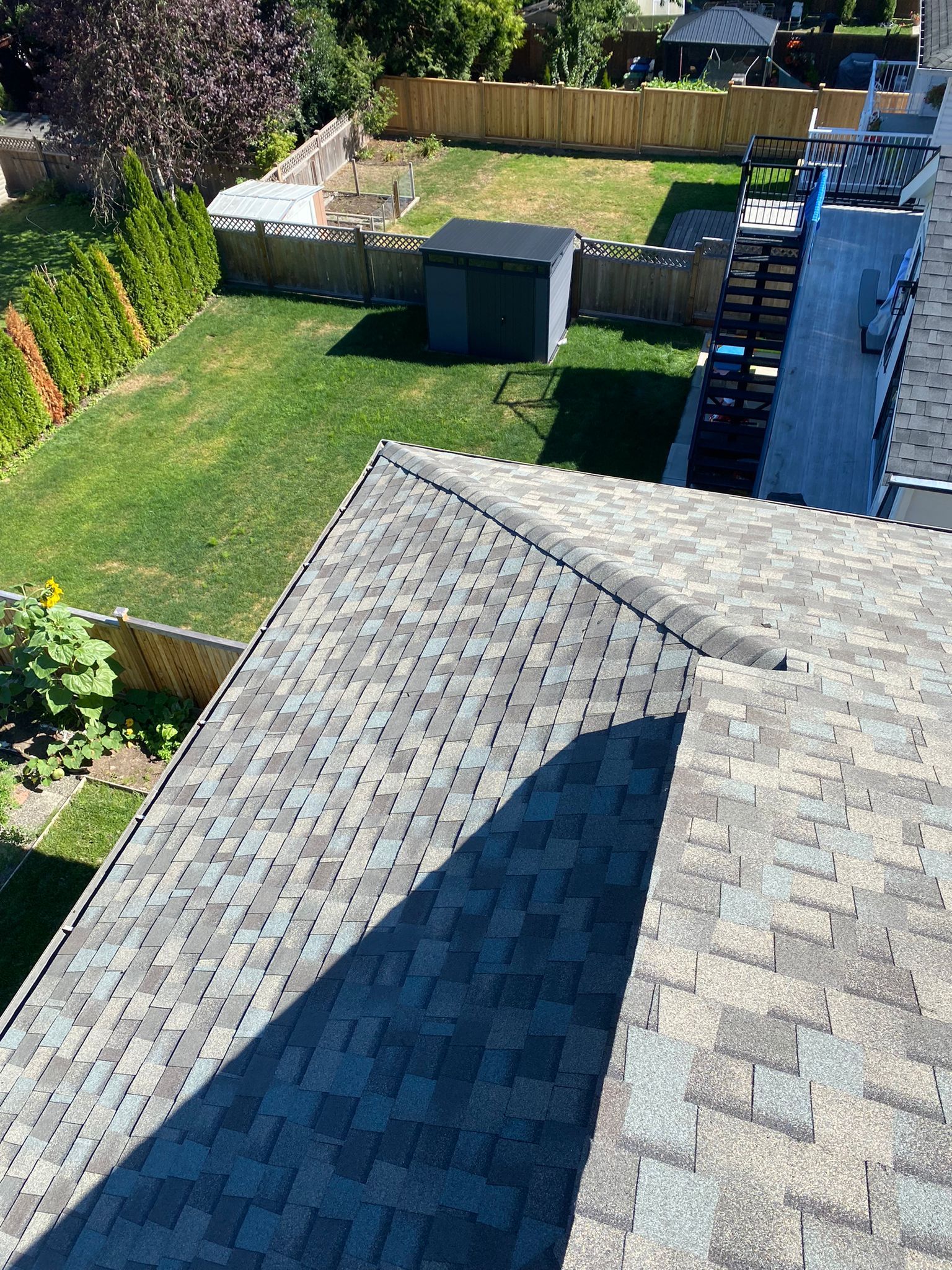 An aerial view of a roof with a shed in the backyard.